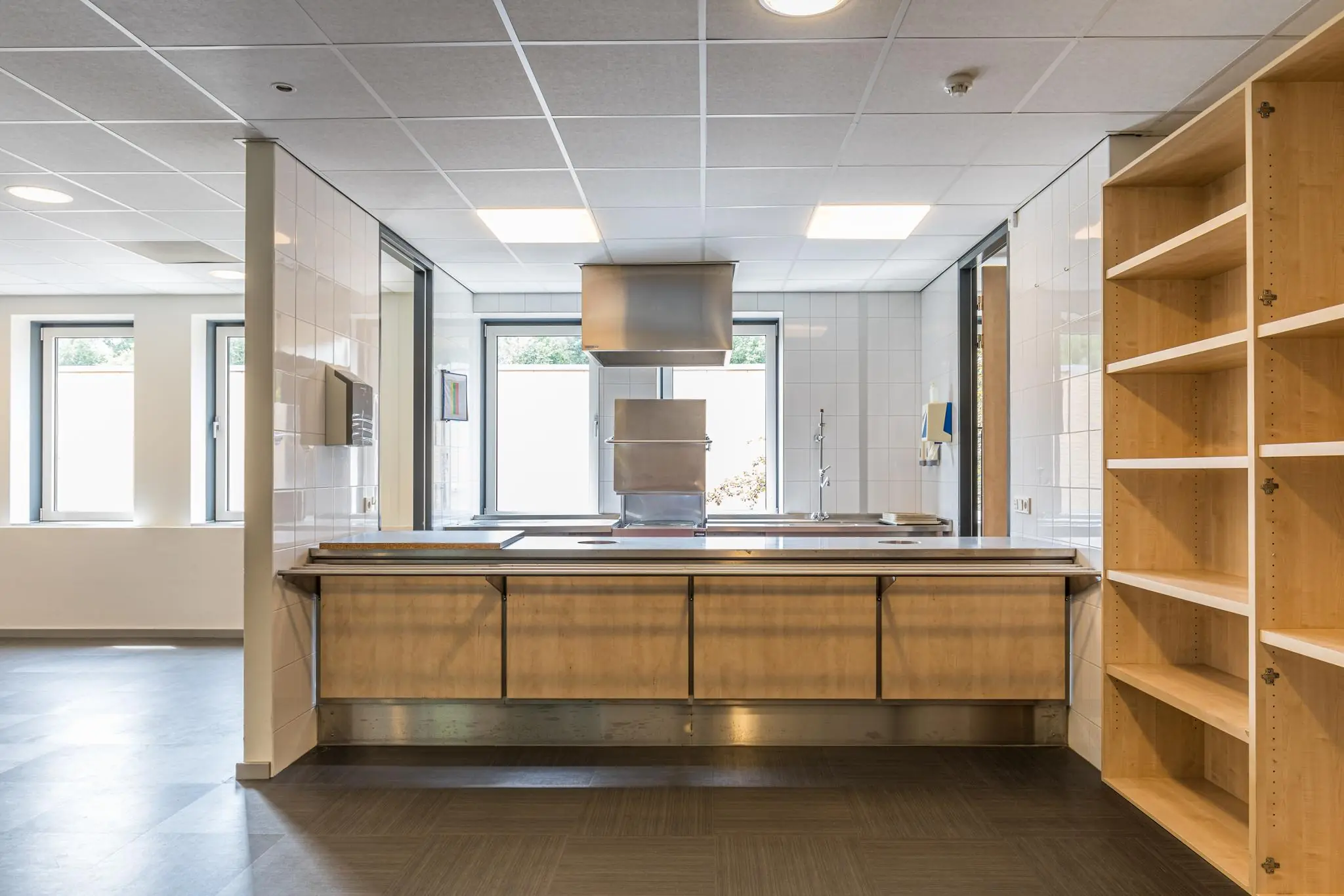 Moderne, lichte keuken met houten fronten, open wandkast en roestvrijstalen afzuigkap aan de Laan Blussé van Oud-Alblas.